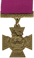 A bronze cross pattée bearing the crown of Saint Edward surmounted by a lion with the inscription 'FOR VALOUR'.  A crimson ribbon is attached.