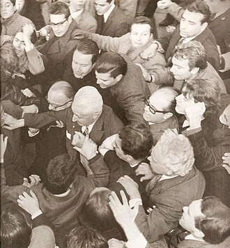 Illia leaving Government House amid a crowd.