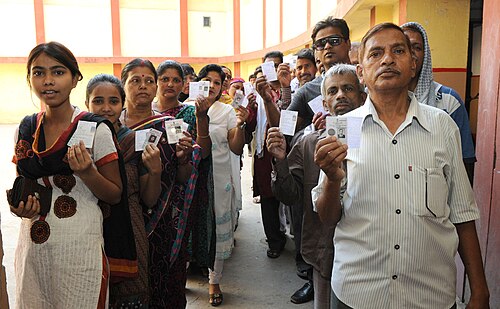 People queuing and showing their identity documents for voting in the 2014 Indian general election