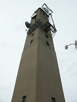 Early stations, like this one near Valparaiso, Indiana, were built of concrete. They housed the electronics mid-way up the tower, behind the window-like openings, to avoid line losses. These were replaced by the steel framework towers as the cost of steel dropped through the 1950s.