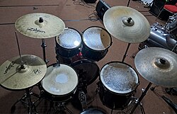 A five-piece kit set up in a rehearsal studio, with two crash cymbals and a smaller 18-inch bass drum.