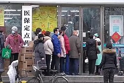 People in Wuhan lining up in front of a drug store to buy surgical masks