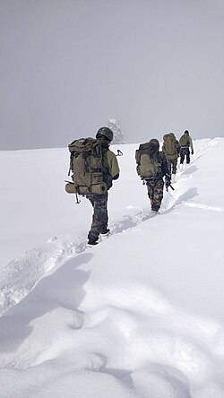 Indian Army soldiers patrolling snow clad mountain range.