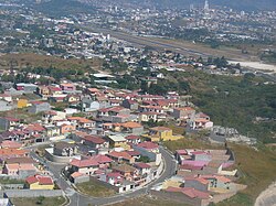 View from aircraft as it banks sharply to align with runway on final approach. Las Hadas residential neighborhood lies below.