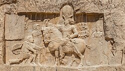 Rock-face relief at Naqsh-e Rostam of Persian emperor Shapur I (on horseback) capturing Roman emperor Valerian (standing) and Philip the Arab (kneeling), suing for peace, following the victory at Edessa.