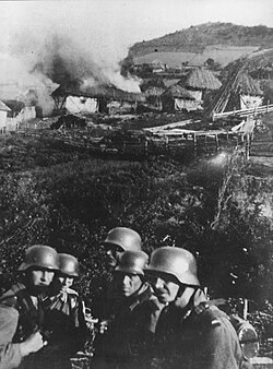 German soldiers set fire to a Serbian village near Mitrovica, c. 1941.