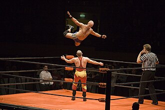 Christopher Daniels performing a flying crossbody on Jonny Storm; like all wrestling moves, this requires coordination between both wrestlers in order to ensure each other's safety.[1]