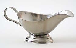 A stainless steel gravy boat