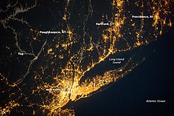 A nighttime view of the New York metropolitan area, with Long Island extending 120 miles (190 km) eastward from Manhattan, the area's central core