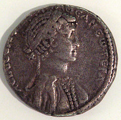 Coin of Cleopatra VII, with her image[38] and a Greek inscription "θεά νεωτέρα" thea neotera, lit. "the younger goddess", one of Cleopatra's adopted titles.[39]