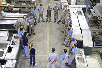 The photo shows a training meeting with factory workers in a stainless steel ecodesign company from Rio de Janeiro, Brazil.