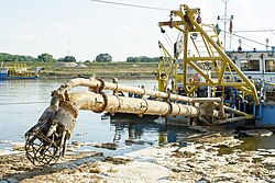 The dredge drag head of a suction dredge barge on the Vistula River in Warsaw, Poland