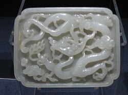 A Yuan dynasty jade belt plaque featuring carved designs of the Azure Dragon, highly regarded as a symbol of Yuan China's maritime strength